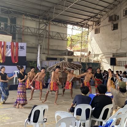 Students perform a traditional dance on the covered-court stage.