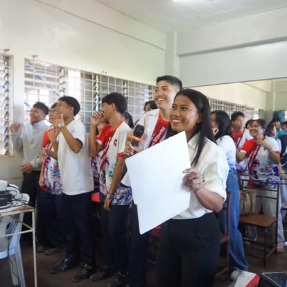 Students sing together during an indoor campus activity.